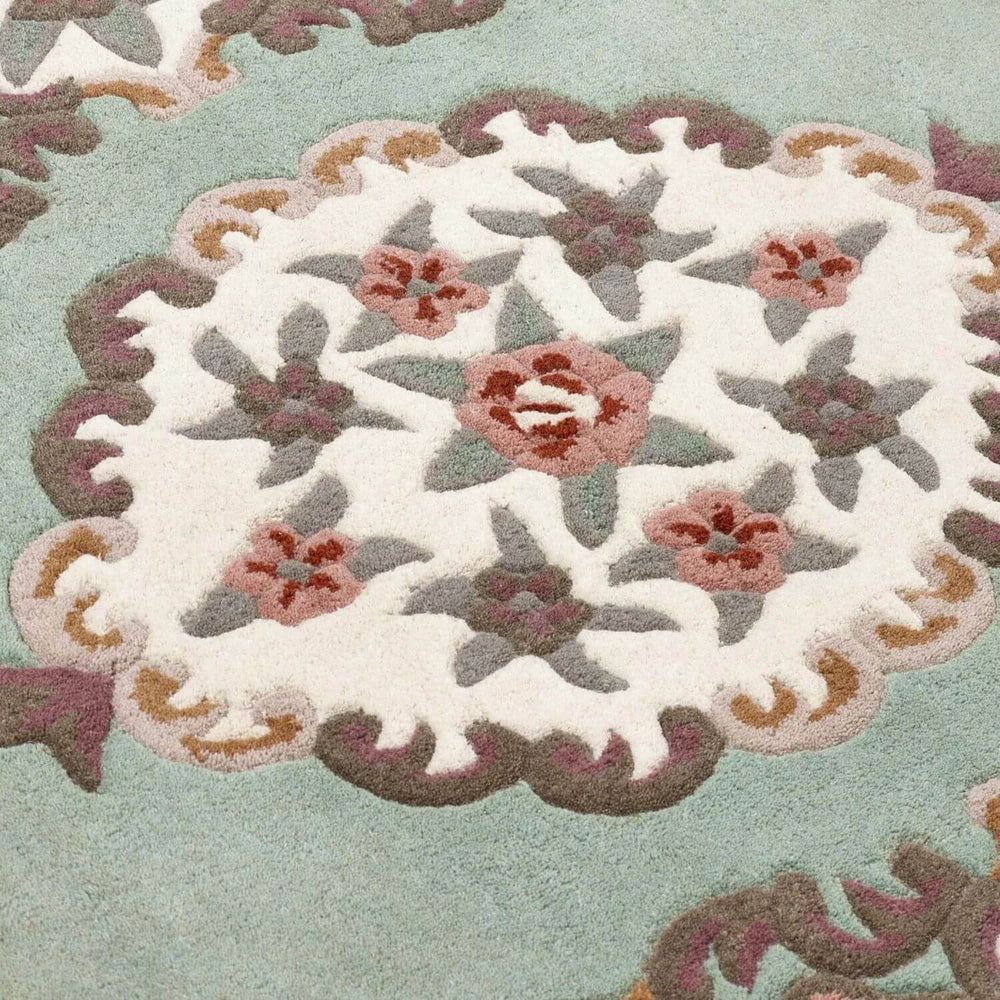 Close-up of a floral patterned rug with a light green background