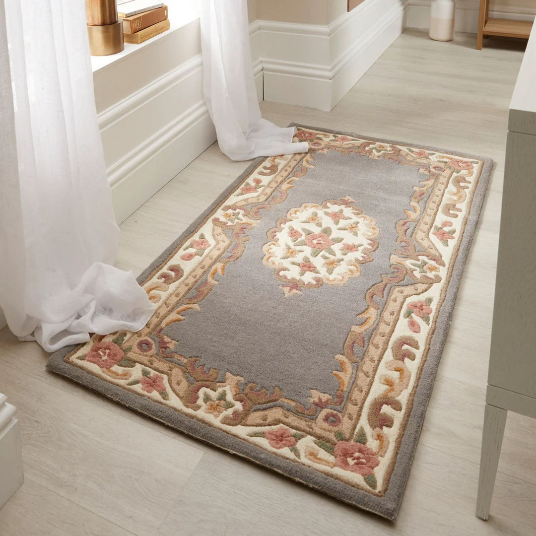 Decorative rug with floral patterns on a light wooden floor.