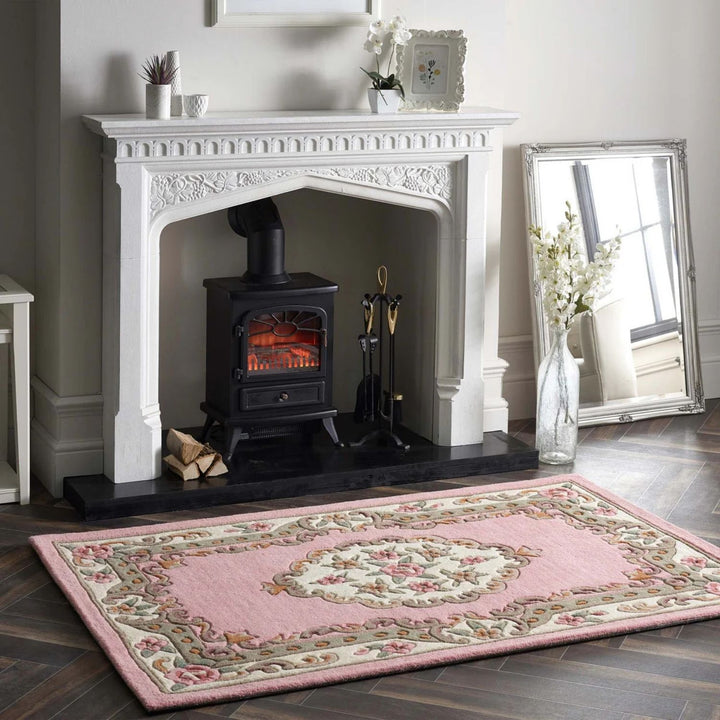 Living room with a white fireplace, pink rug, and decorative items.