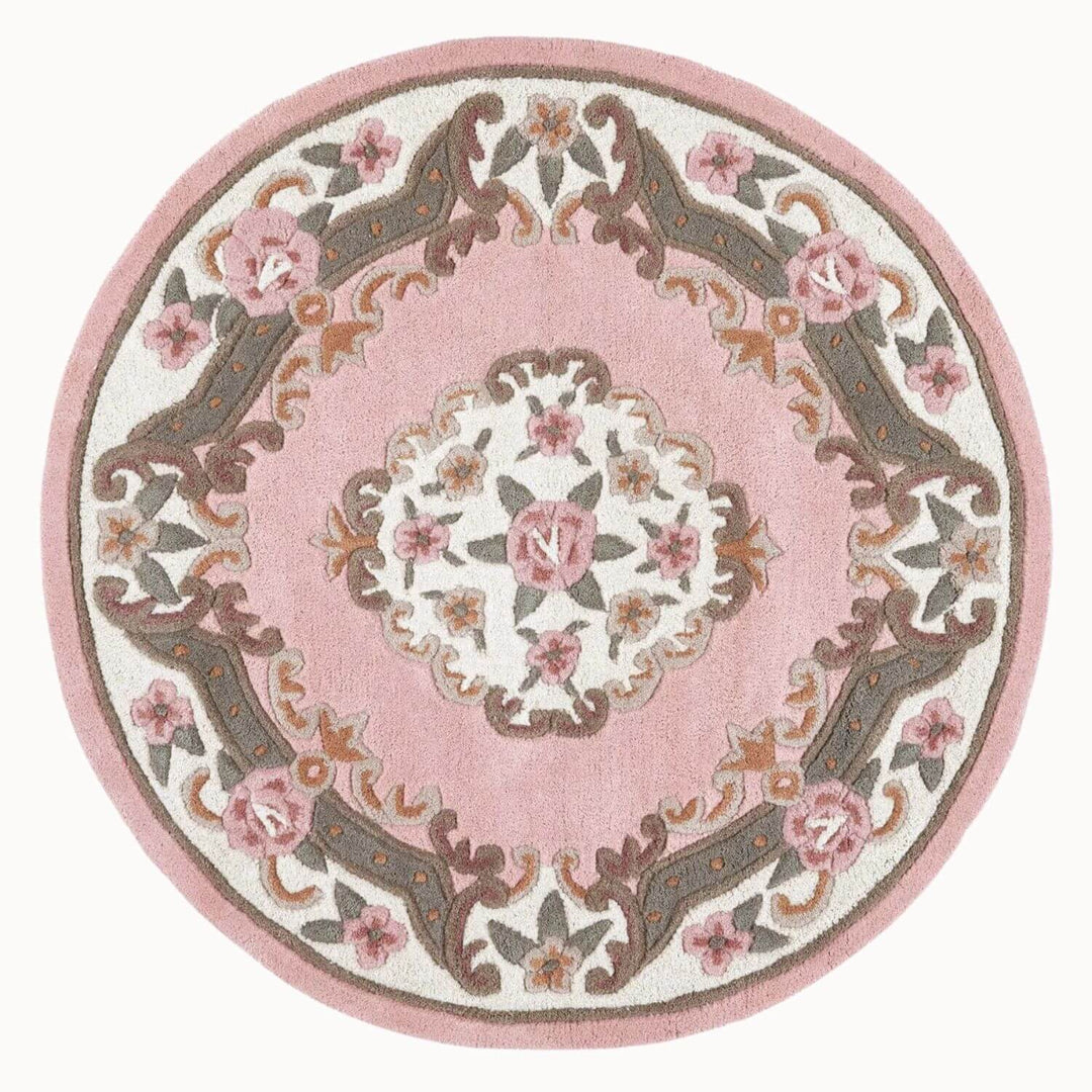 Round pink rug with floral patterns on a white background