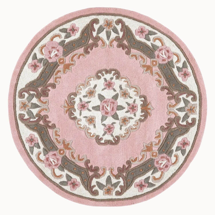 Round pink rug with floral patterns on a white background