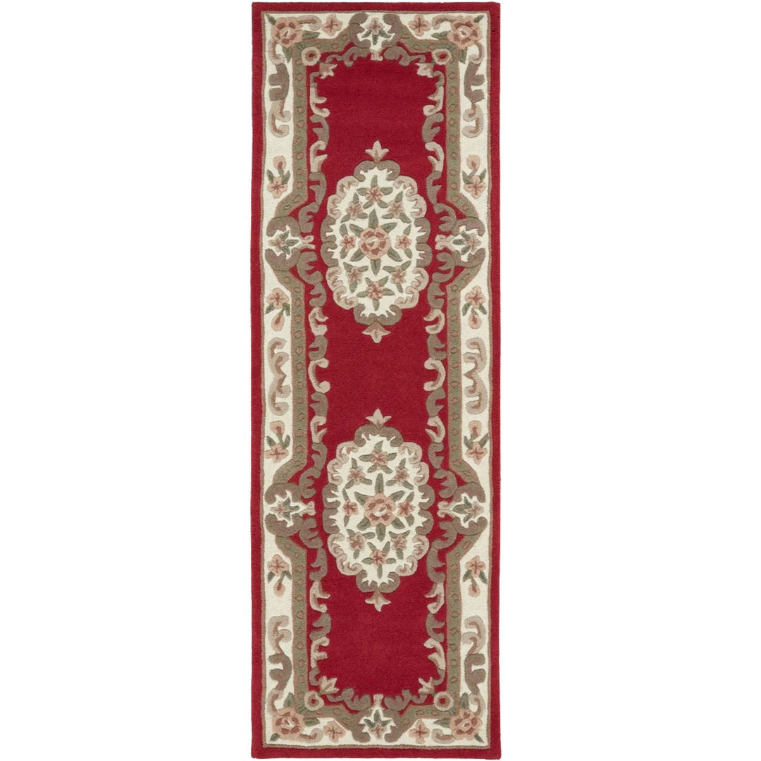 Decorative red and beige runner rug with intricate patterns on a white background