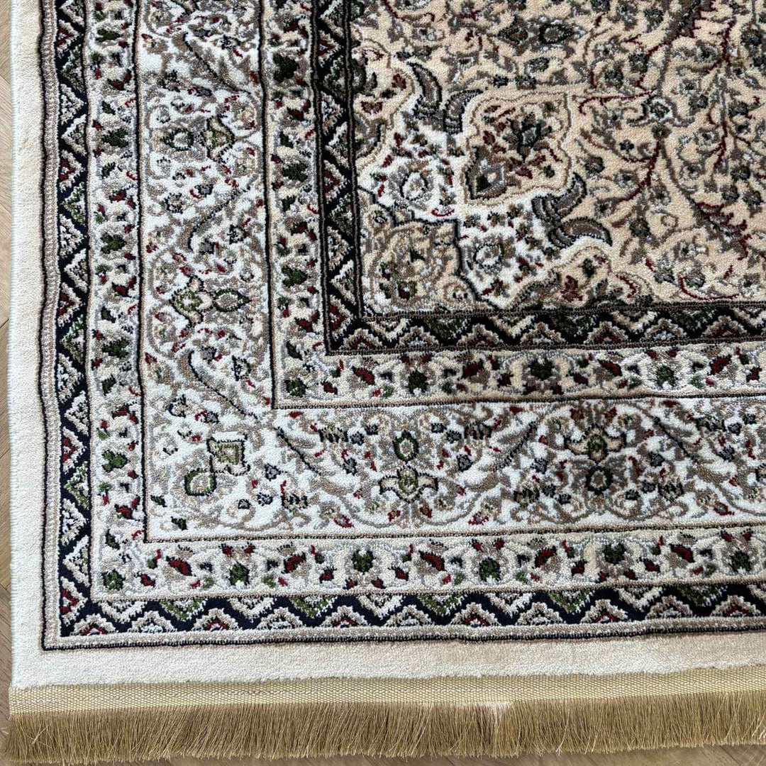 Close-up of a patterned rug with intricate designs and fringes.