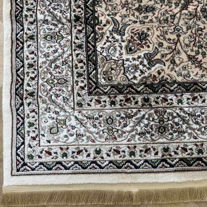 Close-up of a patterned rug with intricate designs and fringes.