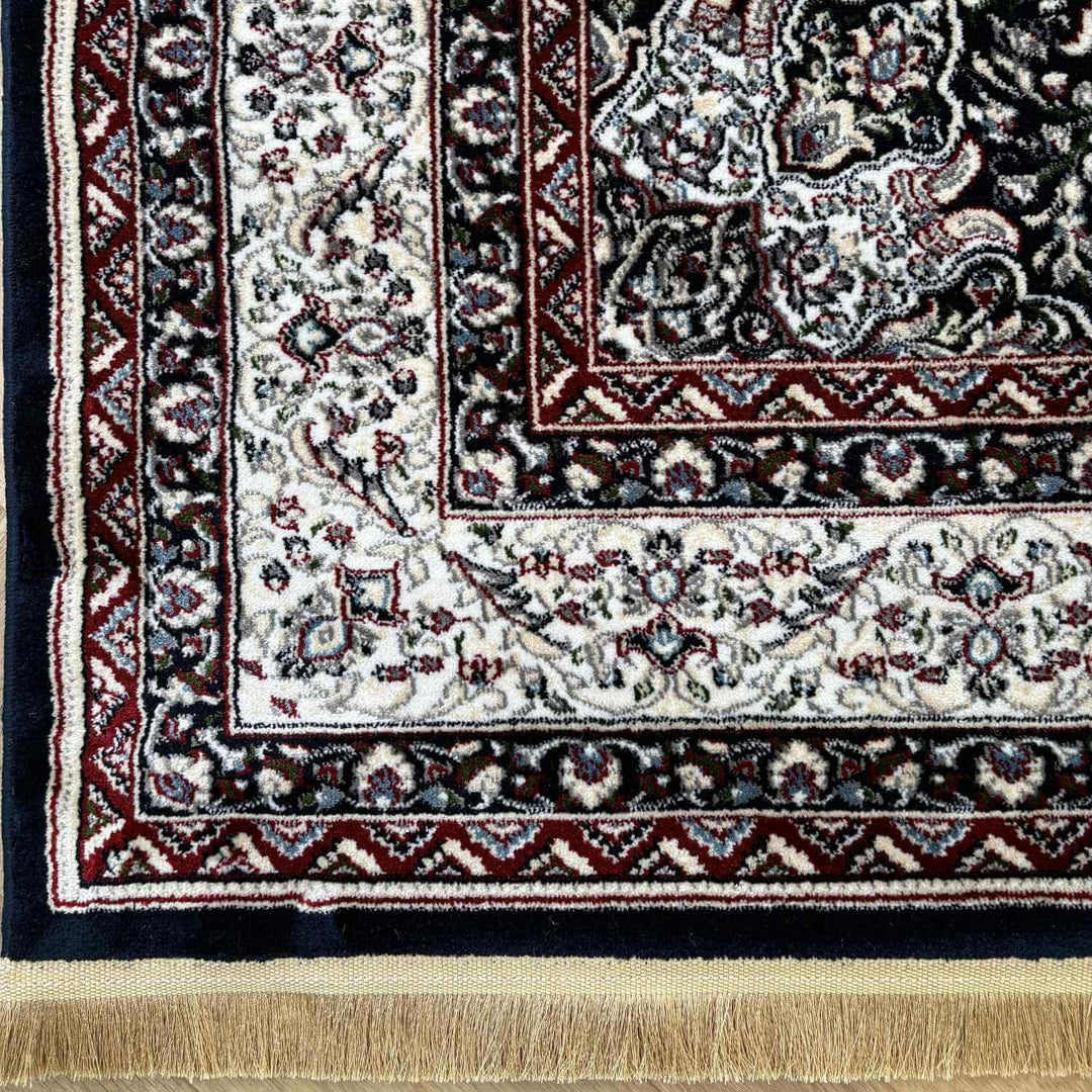 Close-up of a patterned rug with intricate designs and fringes.