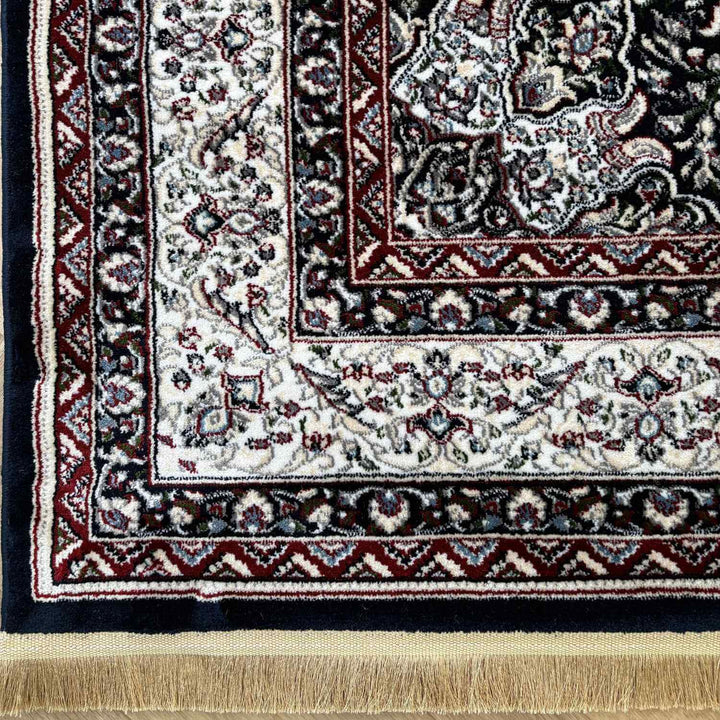 Close-up of a patterned rug with intricate designs and fringes.