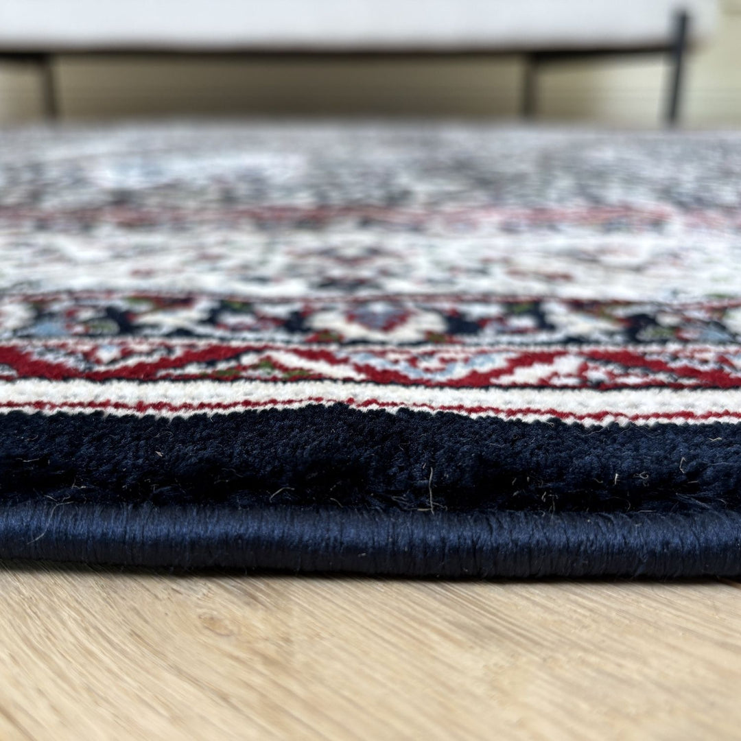 Stack of patterned rugs on a wooden floor