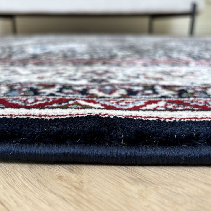 Stack of patterned rugs on a wooden floor
