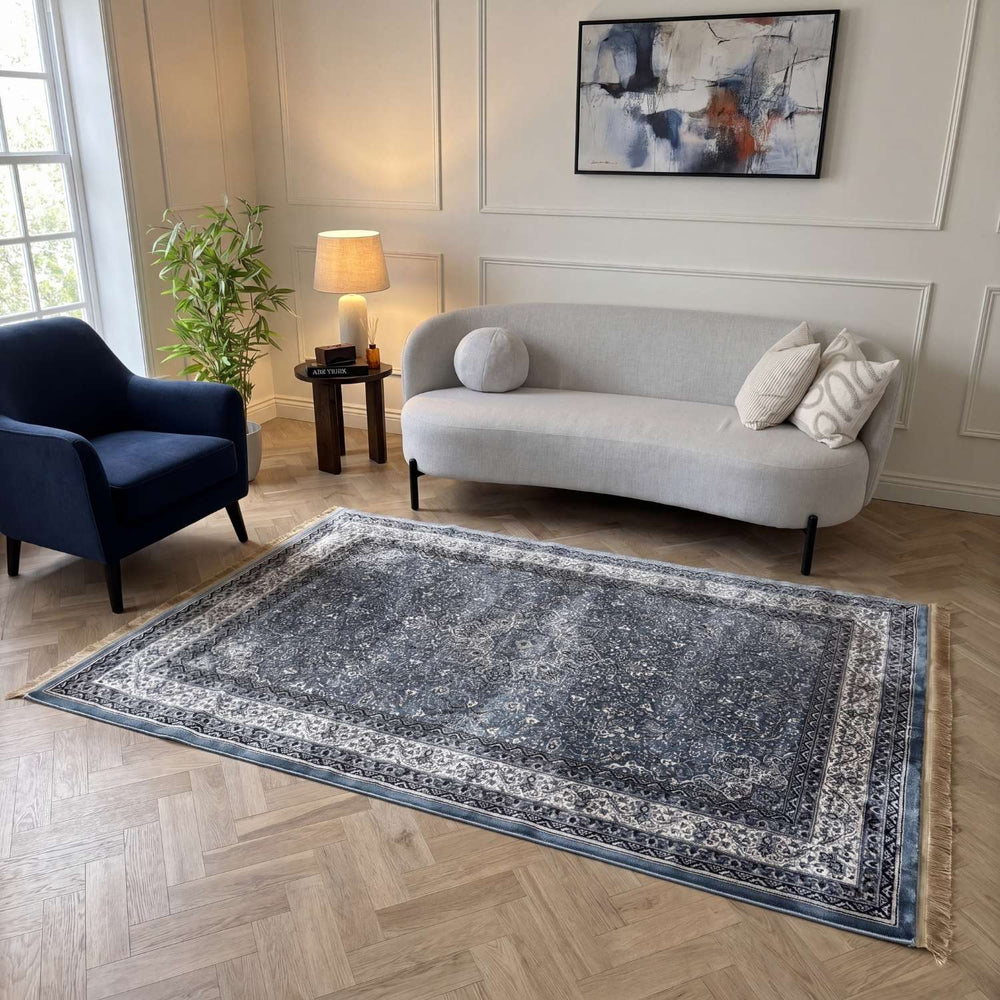 Living room with a gray sofa, blue armchair, and patterned rug.
