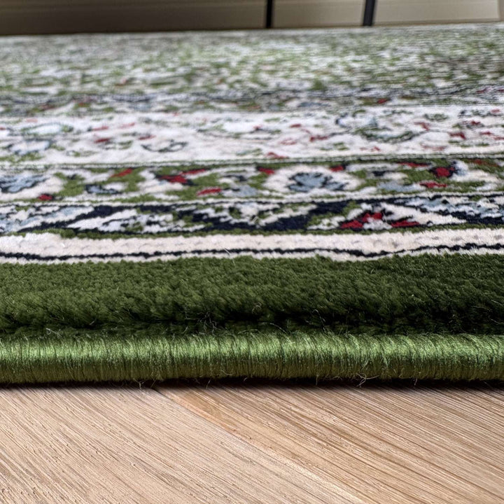 Close-up of a green patterned rug on a wooden floor