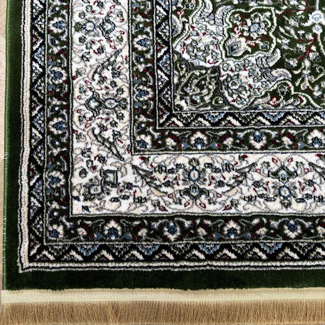Close-up of a patterned rug with intricate designs and fringes.