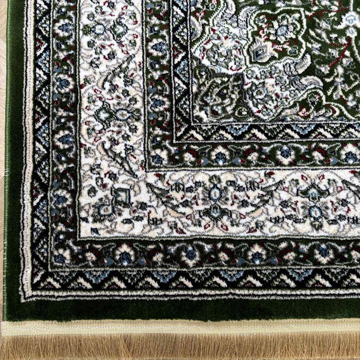 Close-up of a patterned rug with intricate designs and fringes.