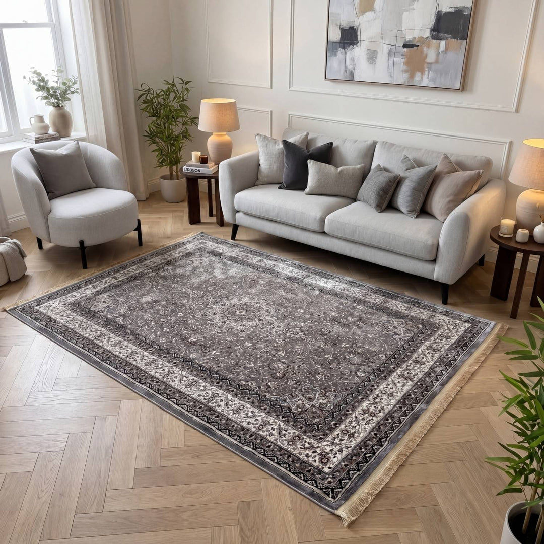Living room with a gray sofa, armchair, and decorative rug.