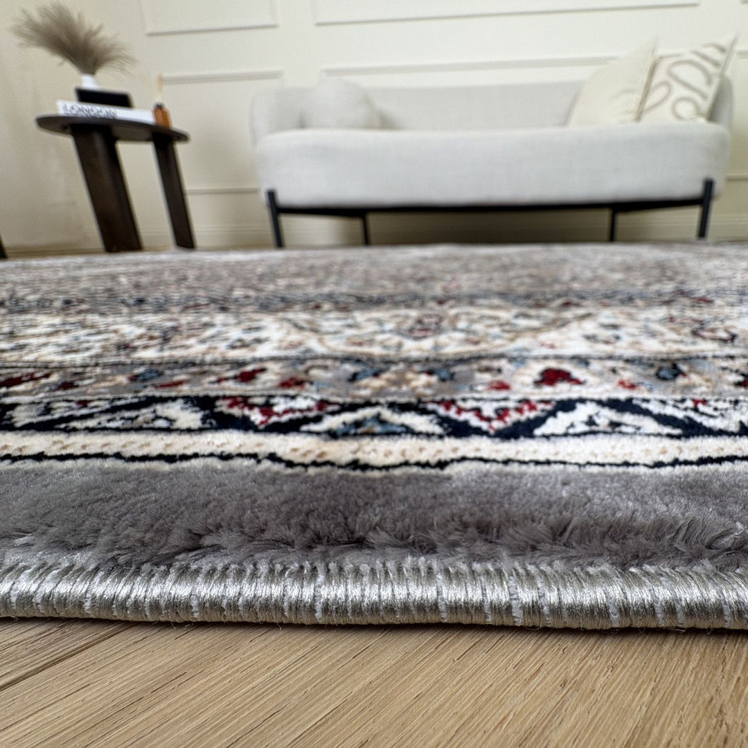 Patterned rug on a wooden floor with a blurred background