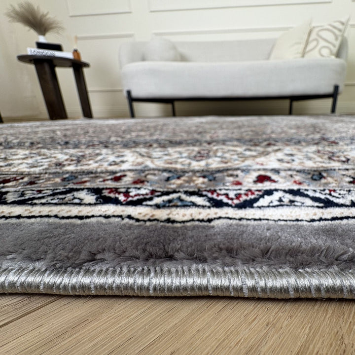 Patterned rug on a wooden floor with a blurred background