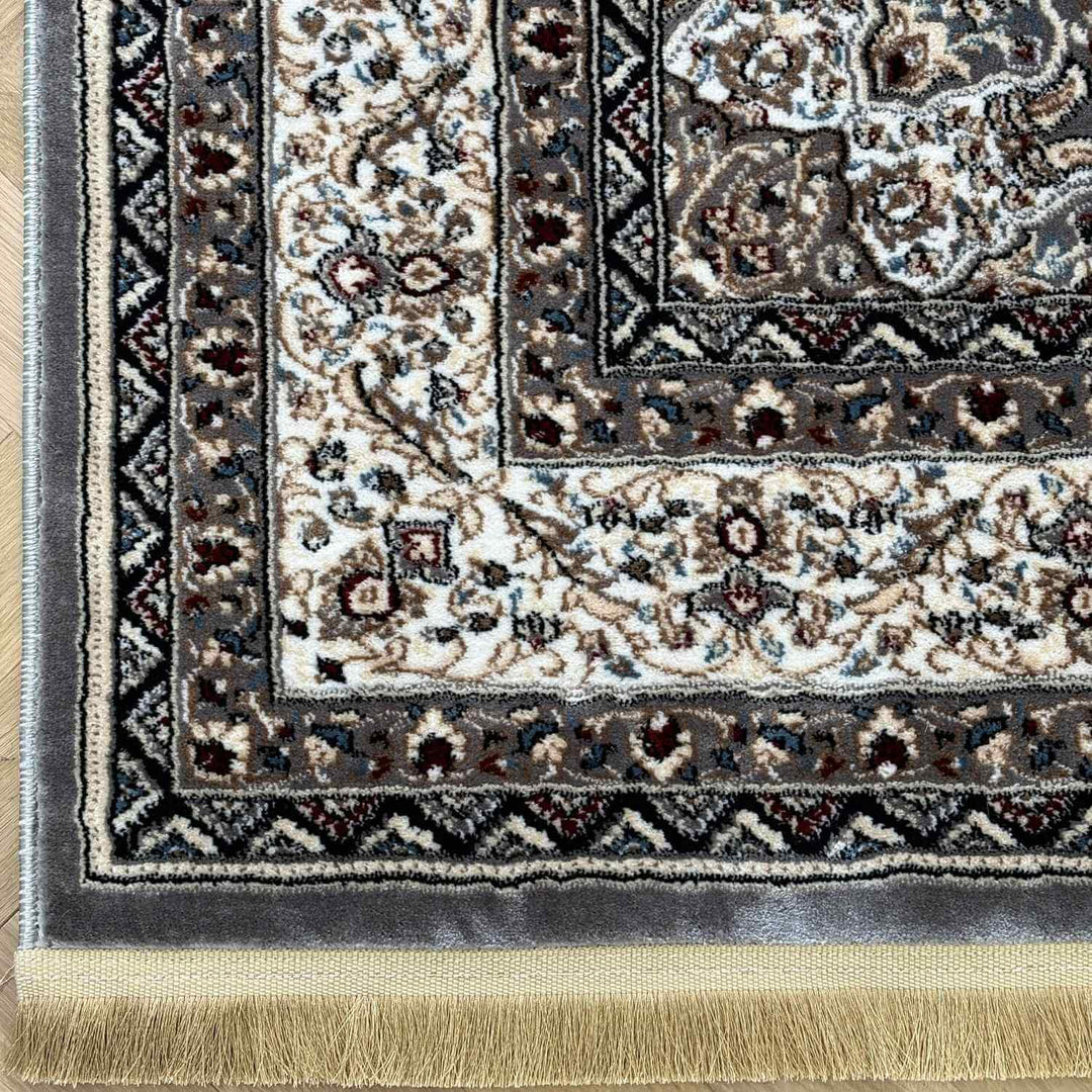 Close-up of a patterned rug with intricate designs and fringes.
