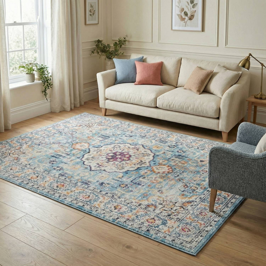 Living room with a patterned rug, beige sofa, and gray armchair.