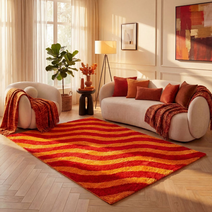 Living room with a red and orange striped rug, white sofa, and abstract painting.