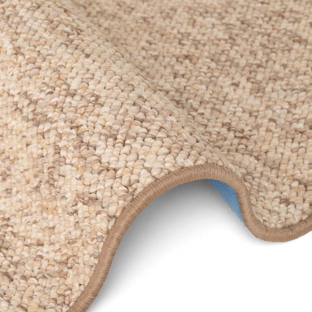 Close-up of a beige textured rug corner on a white background