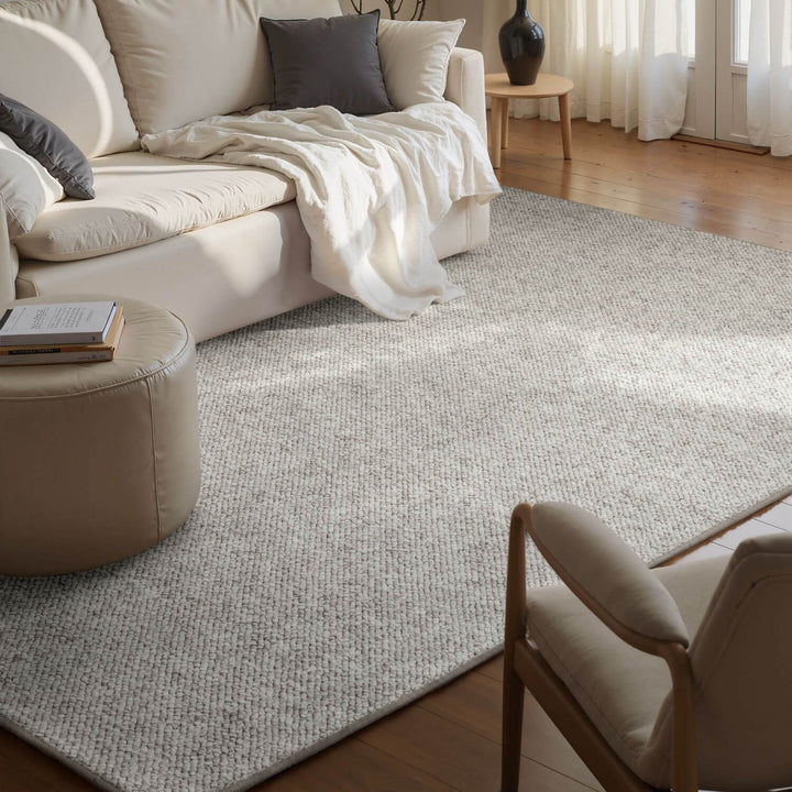Living room with a beige sofa, rug, and chair.
