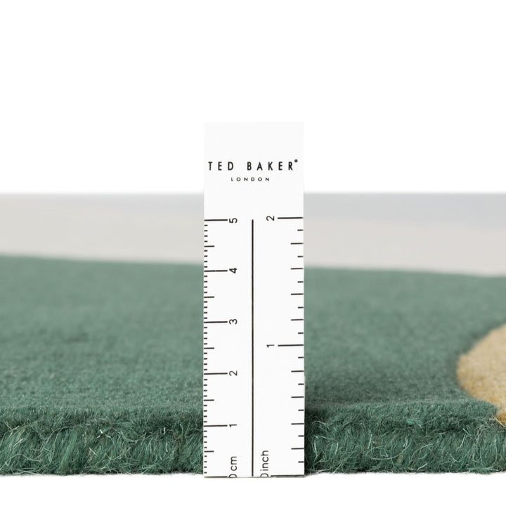 Green fabric with a ruler for scale and 'Ted Baker' branding.